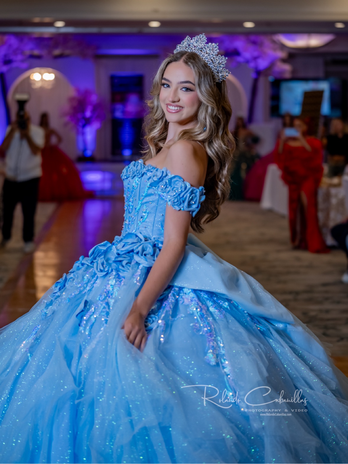 Quinceañera in a sparkling blue gown and crown, photographed by Rolando Cabanillas