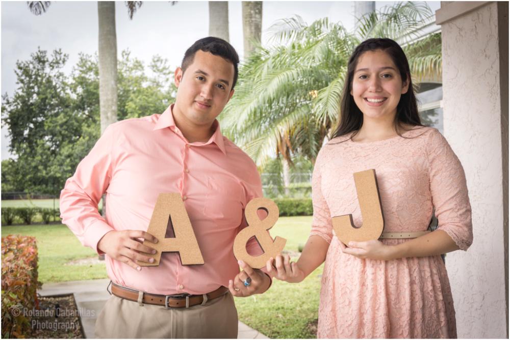 Engaged couple holding wooden letters A and J outdoors